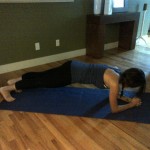 FOREARM PLANK
Begin in a modified plank position on your forearms, hands clasped together. Brace your abs in tight and press down through your shoulders and arms.